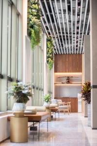 香港木的地酒店  的大堂设有桌子和盆栽天花板。