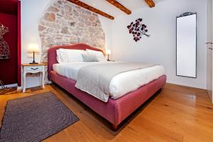 罗维尼Apartments Casa De Amicis的一间卧室设有一张大床和石墙
