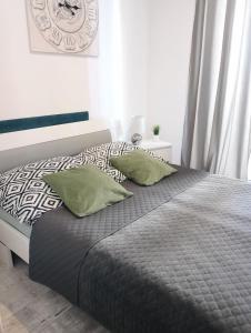 卢宾Apartament Leśny的卧室内的一张带两个绿色枕头的床