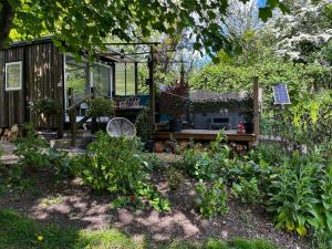灵伍德Lynbrook Cabin and Hot Tub, New Forest的一个带长凳和房子的花园