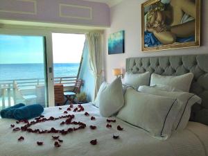 桑盖特The luxury Beach property - Oceanbreeze的一间卧室,床上有玫瑰花床