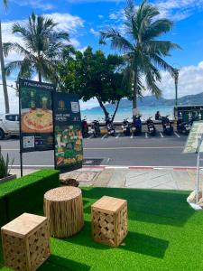芭东海滩Garden Beach Sea View Patong的 ⁇ 染一个长椅和棕榈树的公园