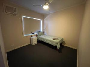 南黑德兰Four bedroom House on Masters South Hedland的一间小卧室,配有床和窗户