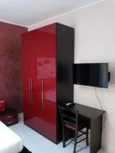 杰拉Bed & Breakfast 21的红色的橱柜,配有书桌和电视