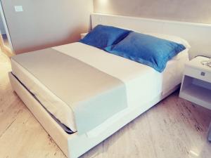 瓦斯托EUROPA Hotel的一张白色的床,上面有蓝色枕头