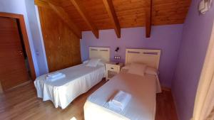 特拉马卡斯蒂拉·德·滕巴达之家乡村旅馆的配有紫色墙壁和木地板的客房内的两张床