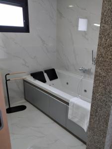 吉尔斯Vonando的白色的浴室设有浴缸和水槽。