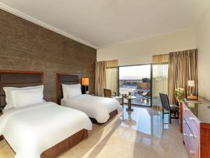 索瓦马死海瑞享Spa度假酒店的酒店客房配有两张床、一张书桌和一张书桌
