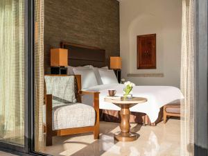 索瓦马死海瑞享Spa度假酒店的一间卧室配有一张床、一把椅子和一张桌子
