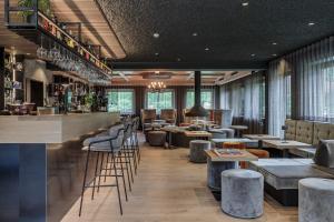 蒙圭尔福克里斯托夫酒店的餐厅设有酒吧,配有凳子和桌子