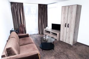 考纳斯HOF HOTEL的带沙发和电视的客厅