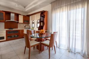 根纳迪Casa di Vasia的厨房配有玻璃桌、椅子和窗户