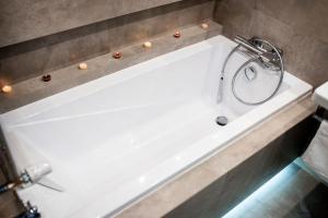 若雷Apartament Południowy W80的浴室设有带淋浴的白色浴缸。