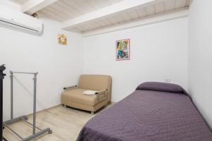 奥尔比亚Villetta a Mare的一间卧室配有一张床和一把椅子