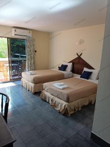 纳仲天Ban Nam Mao Resort的酒店客房设有两张床和一个阳台。