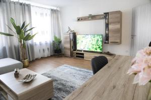 杜伊斯堡T&K Apartments near Messe Fair Trade Düsseldorf und Airport 1B的客厅配有桌子和电视