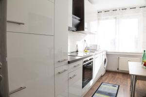 杜伊斯堡T&K Apartments near Messe Fair Trade Düsseldorf und Airport 1B的白色的厨房配有白色橱柜和窗户