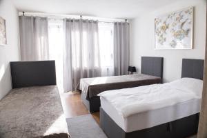 杜伊斯堡T&K Apartments near Messe Fair Trade Düsseldorf und Airport 1B的酒店客房设有两张床和窗户。