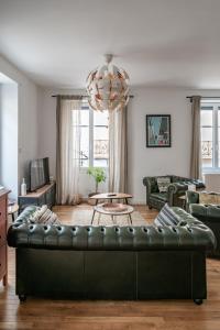 维希Grande Maison Vichy - Maison ou Appartements en Centre ville的客厅配有黑色真皮沙发