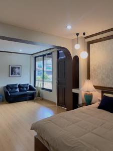 清迈October Hostel ChiangMai的一间大卧室,配有一张床和一张沙发