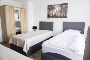 杜伊斯堡T&K Apartments near Messe Fair Trade Düsseldorf und Airport 2A的酒店客房,设有两张床和镜子