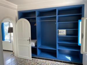 西迪·布·赛义德Chez ADAC的一间设有蓝色架子和白色门的房间