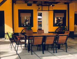 Sebeşu de SusCasa Ardeleneasca的黄色墙前的一张木桌和椅子