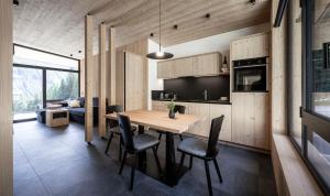 瓦尔迪维泽Stelza Nature Chalet的厨房以及带木桌和椅子的用餐室。