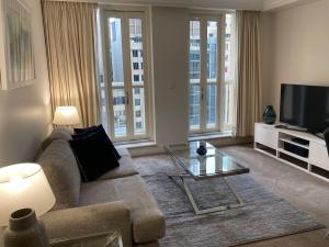 悉尼Huge Exec Apartment -Fantastic CBD Location B21001的带沙发和电视的客厅