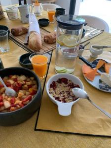 讷沙泰勒阿尔代洛Art de l'Ô的一张桌子,上面放着一碗食物和一碗水果