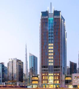 迪拜Grand Millennium Business Bay的一座高大的建筑,城市里灯火通明