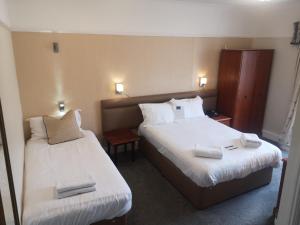 普里茅斯因维克塔酒店的酒店客房,配有两张带白色床单的床