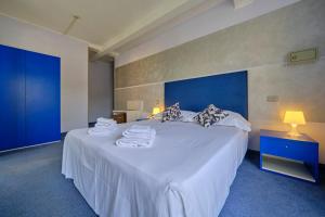 西尔米奥奈HOTEL VITTORIA的卧室配有带毛巾的大型白色床