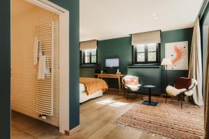 圣马尔滕斯·拉特姆杜普切旅馆的一间卧室设有绿色的墙壁、一张床和一张书桌