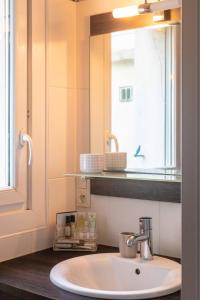 布雷斯特Brest : charmant appartement hypercentre的浴室设有水槽、镜子和窗户