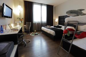 热那亚热那亚假日酒店的酒店客房设有两张床和一张带电脑的书桌