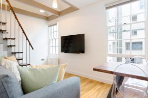 伦敦Spacious 4 bedrooms flat in New Oxford Street的一间带电视和沙发的客厅