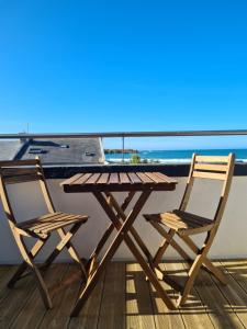 桑泰克Les Suites du Dossen的海景阳台上配有一张木桌和两把椅子