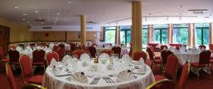 Vienne-le-Château图里皮埃尔餐厅酒店的宴会厅配有白色桌子和红色椅子