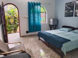 安君纳Rosetta Guesthouse的卧室配有床、椅子和窗户。