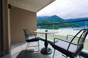 奈福尔斯City Hotel Glarnerland的设有一个配有桌子和两把椅子的阳台,并享有美景。