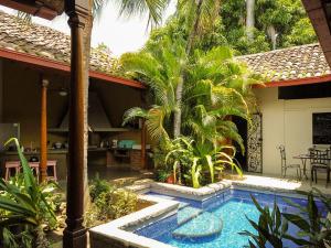 格拉纳达Miskitu casa boutique的棕榈树屋前的游泳池
