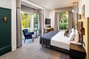 牛津Mercure Oxford Hawkwell House Hotel的酒店客房带一张床、椅子和窗户