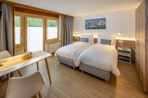 采尔马特安妮塔酒店的配有一张床和一张书桌的酒店客房