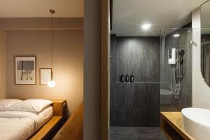 清迈Maplewood Hotel Chiangmai的带淋浴、床和盥洗盆的浴室