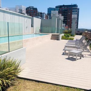 布宜诺斯艾利斯Edificio fresh pampa的一座带长凳的建筑屋顶上的游泳池