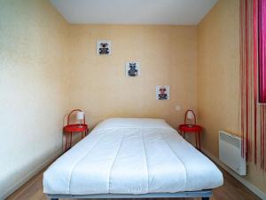 昂代Appartement Hendaye, 2 pièces, 5 personnes - FR-1-2-299的一间卧室配有一张床和两张红色椅子