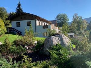 贝希特斯加登Alpenvilla Berchtesgaden Appartements的前面有一块大石头的房子
