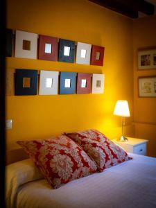 里约克维La Casona de Las Meninas的一间卧室配有一张带红色枕头和黄色墙壁的床