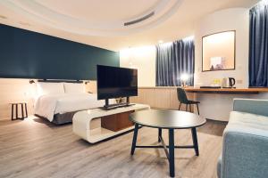 台北雀客藏居台北南港的一间酒店客房,配有一张床、一台电视和一张桌子